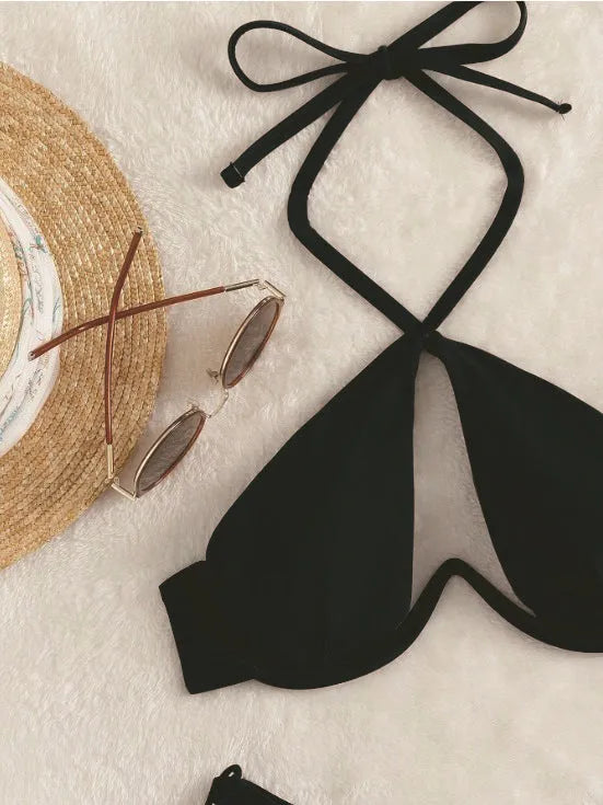 Women's solid colour halter bikini swimsuit with backless briefs in black, blue, or brown.
