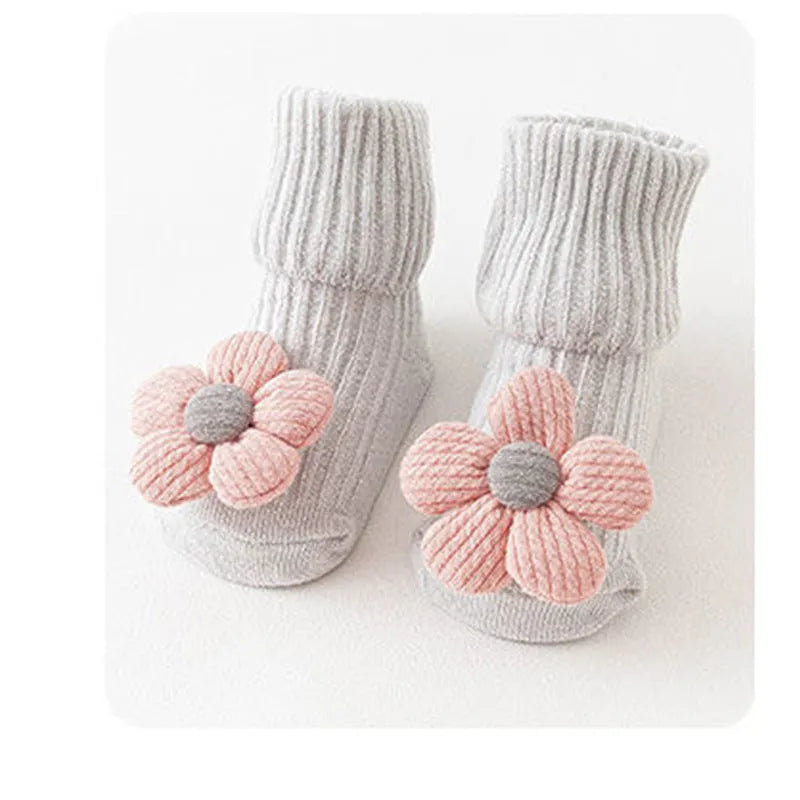 Cotton baby floor socks in a selection of colours and patterns like panda, lion, and bows, shown in sizes for infants.
