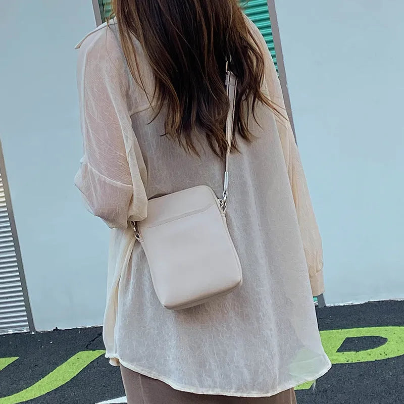 Small solid colour PU leather crossbody shoulder bag for women in beige, black, green, or khaki.