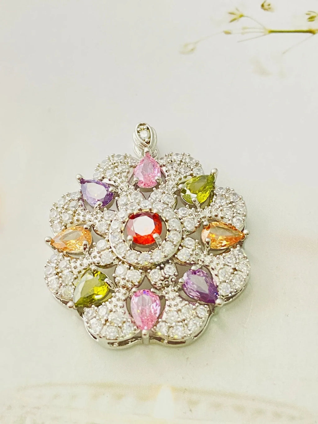 Close-up of a women's flower-shaped zircon pendant necklace in a gold colour finish on a chain.