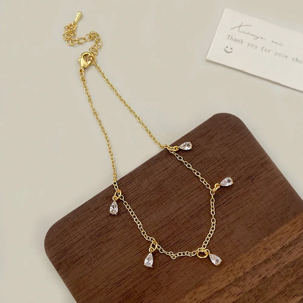 Women's zircon jewellery set showing necklace, earrings, and anklet with geometric meteor shower design