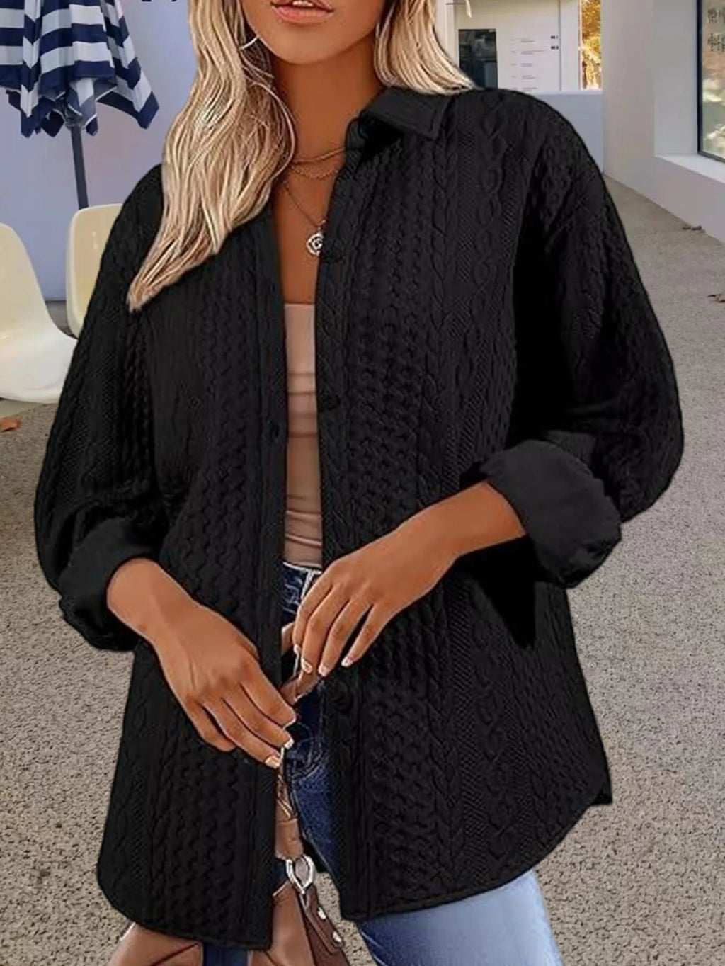 Women's solid colour long-sleeved knitted cardigan in black, shown on a hanger.