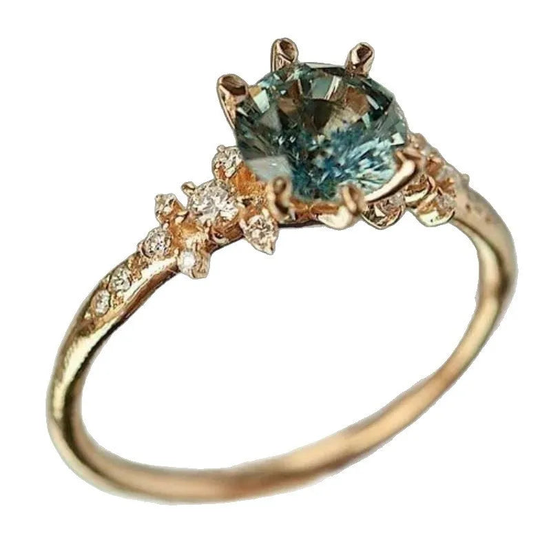 Gold coloured geometric ring with chamfered square pattern and claw-set zircon stones.