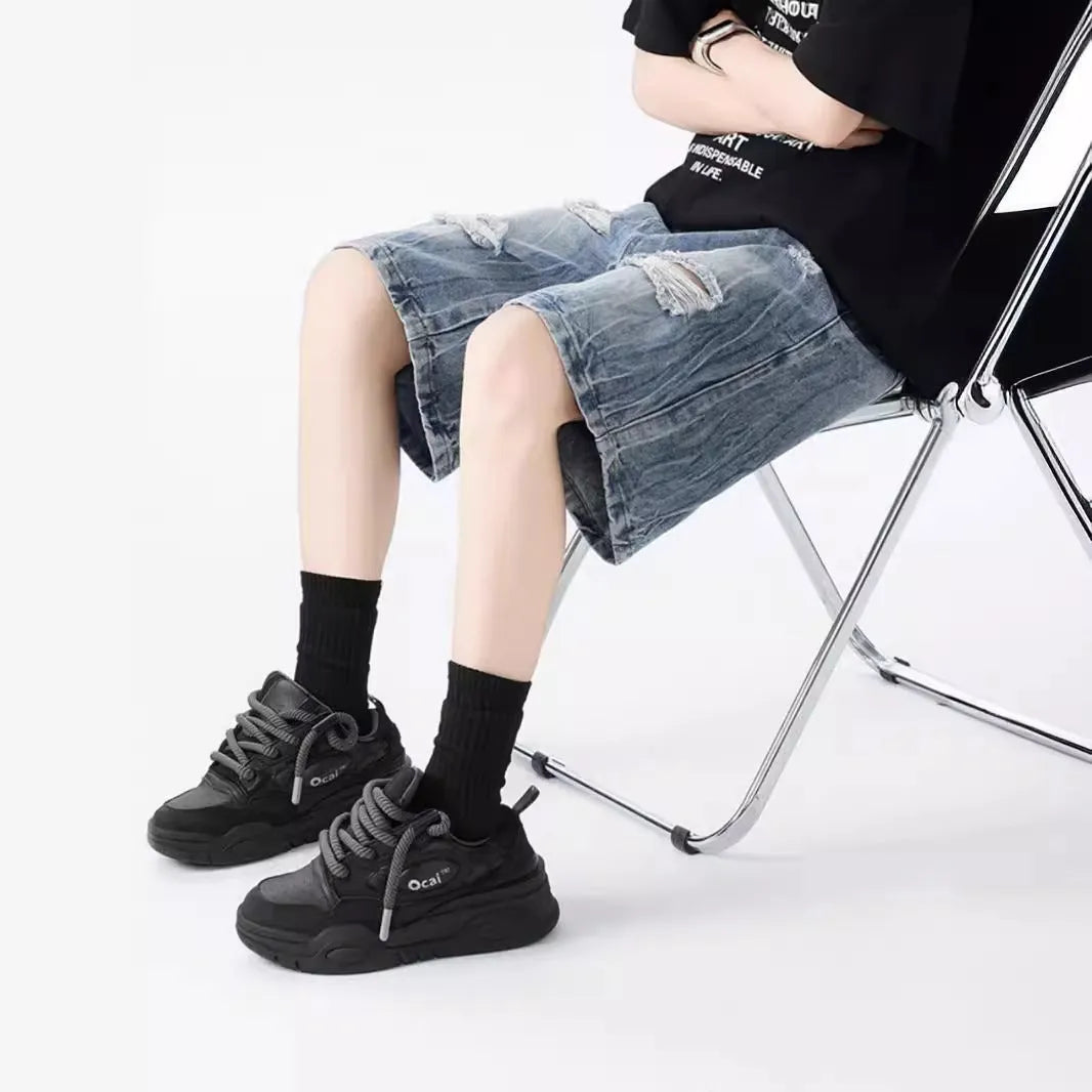 Washed blue denim shorts with ripped detailing on a hanger, showing loose retro fit