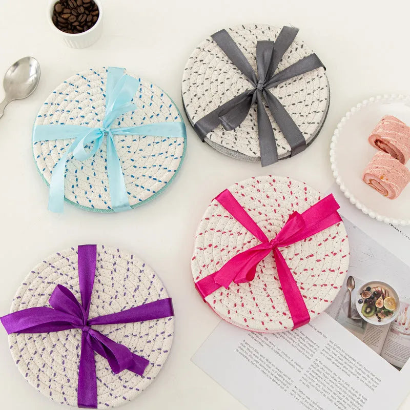 Three round cotton cord coasters in blue colour set on wooden table