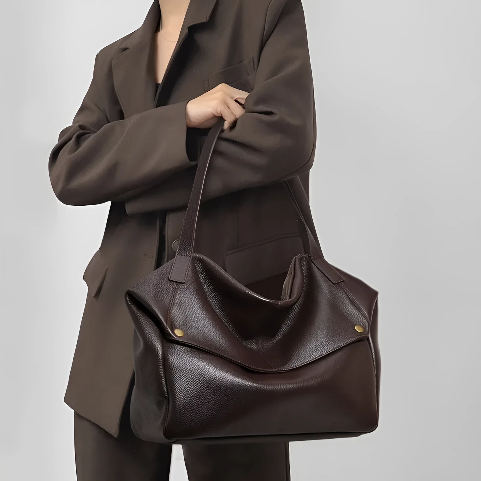 Brown genuine leather women's commuter shoulder bag with horizontal square shape showing internal zippered compartment
