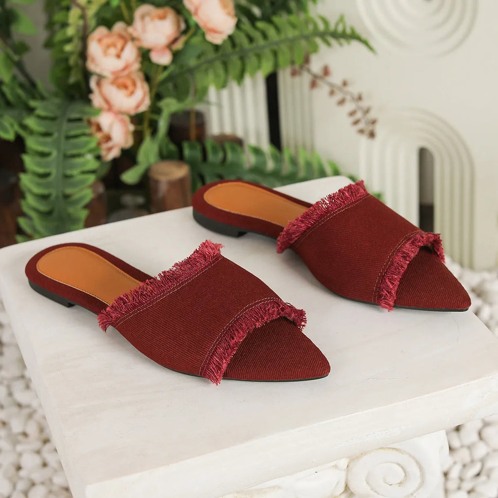 Women's flat denim slippers with tassel detail in apricot colour on a white background.