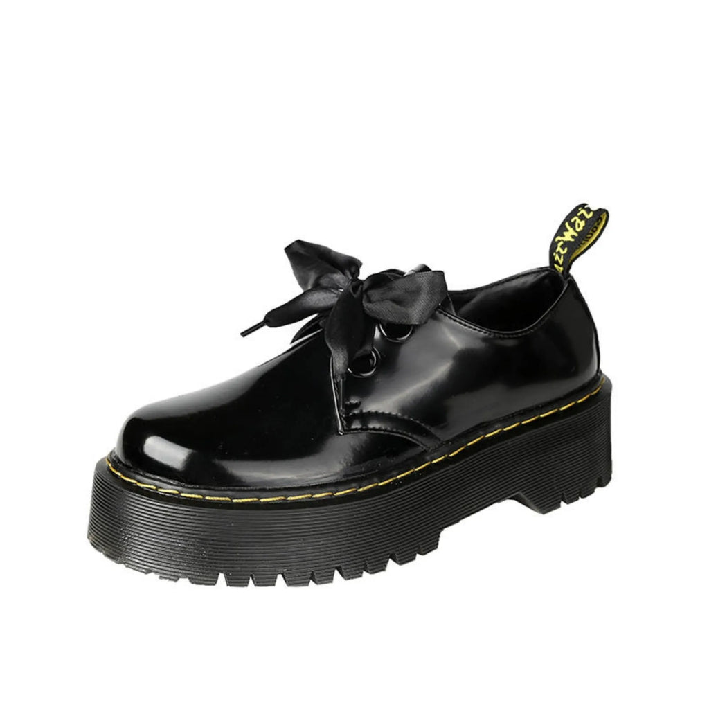 Women's black leather shoes with thick sole, cross strap, and ribbon lacing closure