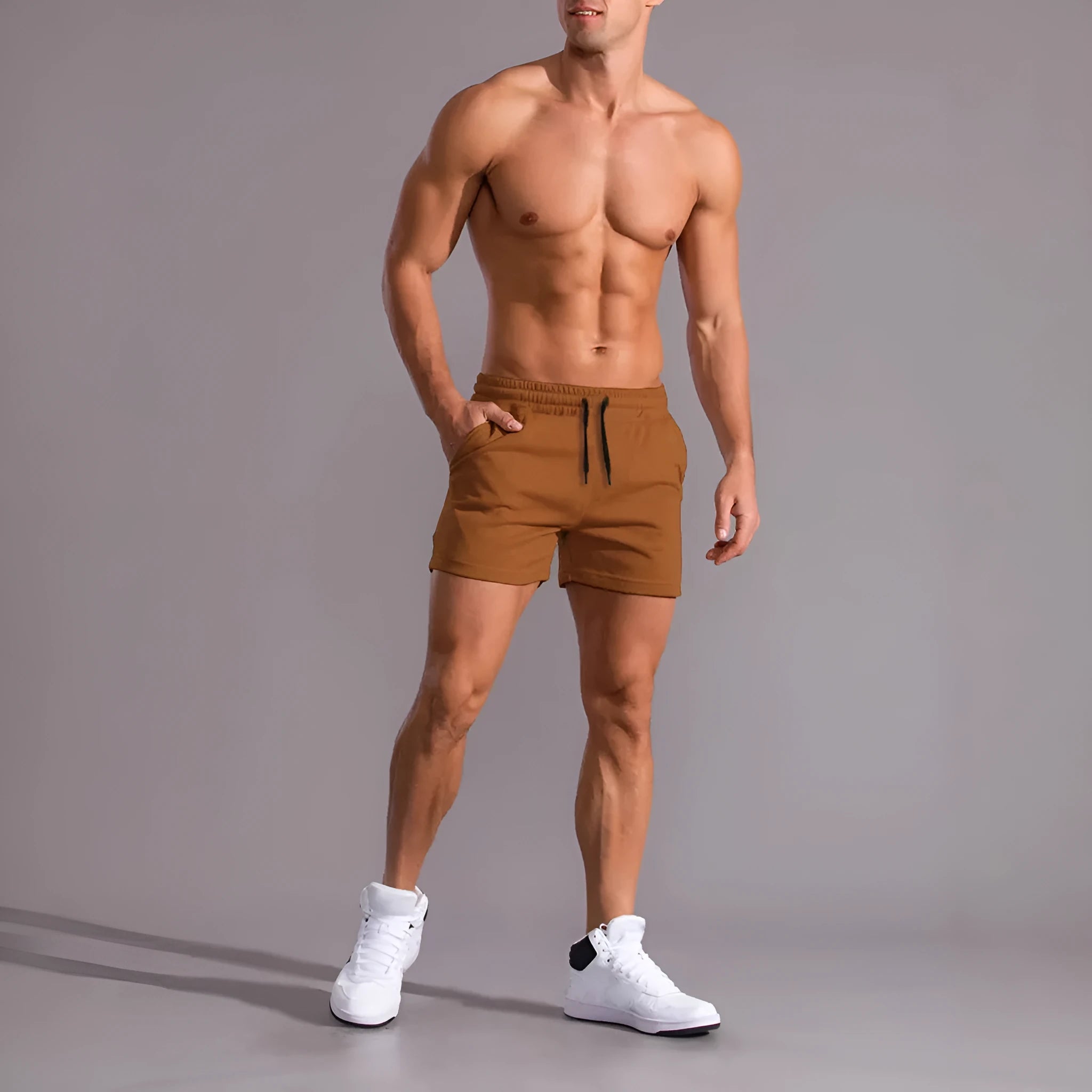 Three men's drawstring shorts in black, khaki, and light brown laid flat, showing loose fit and elasticated fabric.