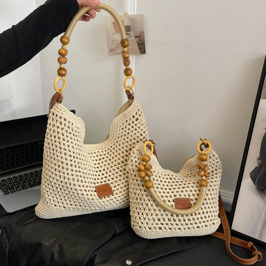 Black knitted bucket tote bag with contrast stitching showing internal zipper compartment