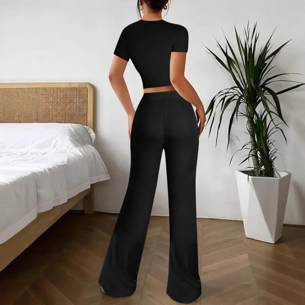 Black women's high waist trousers and short sleeve top coordinated suit set on a hanger.