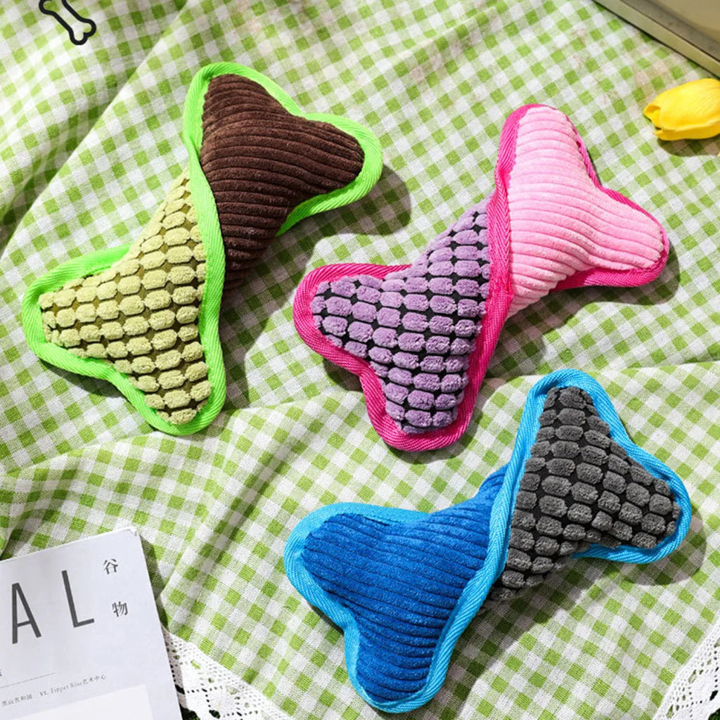 Soft teddy bear dog toy with squeaker and bone accessory in blue, green, and pink colours