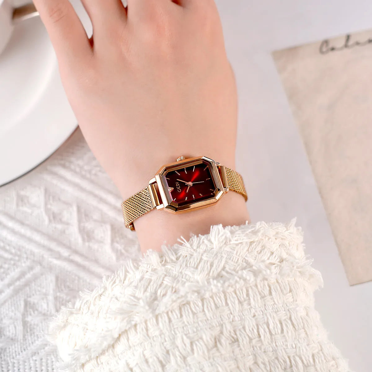 Square retro casual watch for women with rose shell case and choice of coloured dial on wrist.