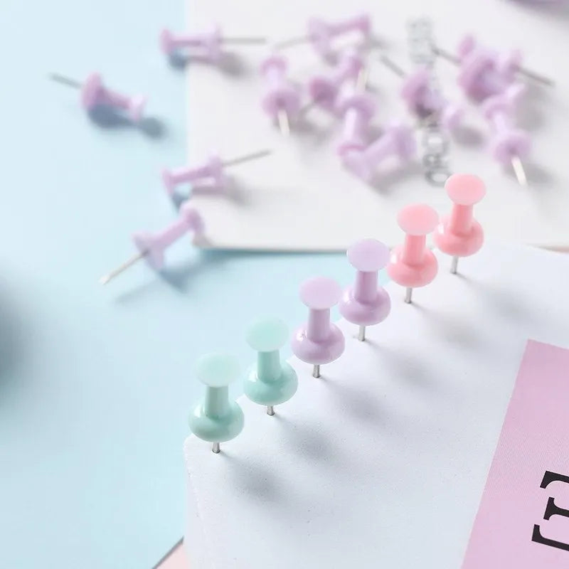 Plastic push pins in macaron colours: cherry blossom pink, mint green and lavender, displayed in small boxes.